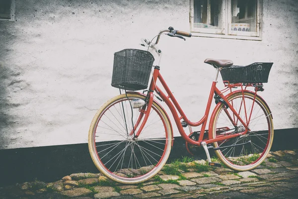 旧市街の石畳の通り沿いのレトロなビンテージ赤い自転車. ストック画像