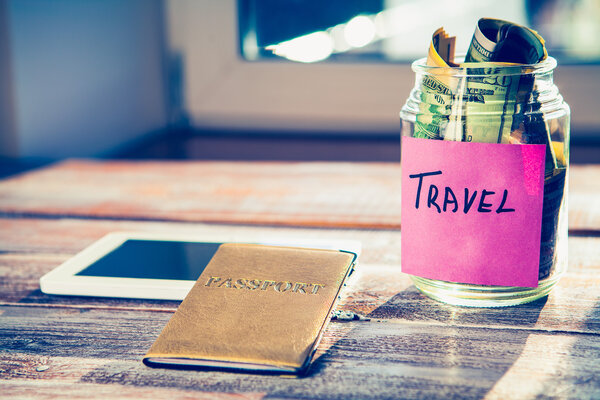 Money and objects for travel isolated on a wooden background