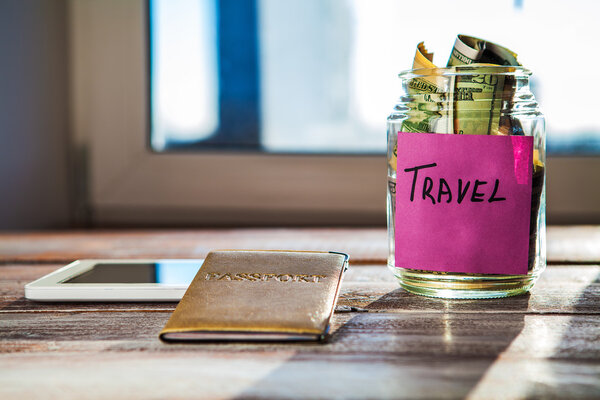 Money and objects for travel isolated on a wooden background