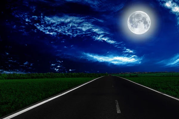 Velocidad noche carretera, una luna se enciende por delante — Foto de Stock