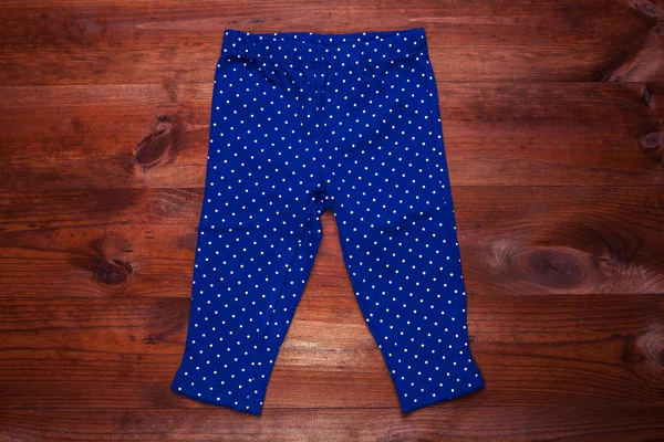 Blue childs leggings isolated on a wooden background — Stock Photo, Image