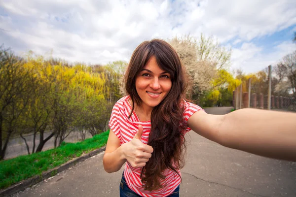 Mladá dívka, takže selfie fotografie v parku — Stock fotografie