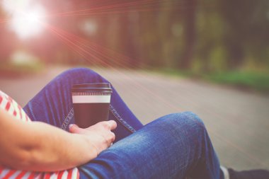 Kahve Kupası ile kız oturuyor