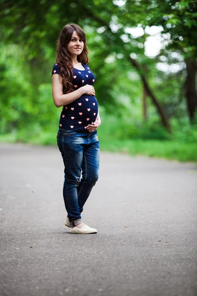 妊娠中の女性が公園を散歩して — ストック写真