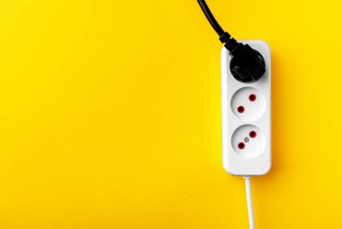 Sarı arkaplanda izole edilmiş elektrik prizi