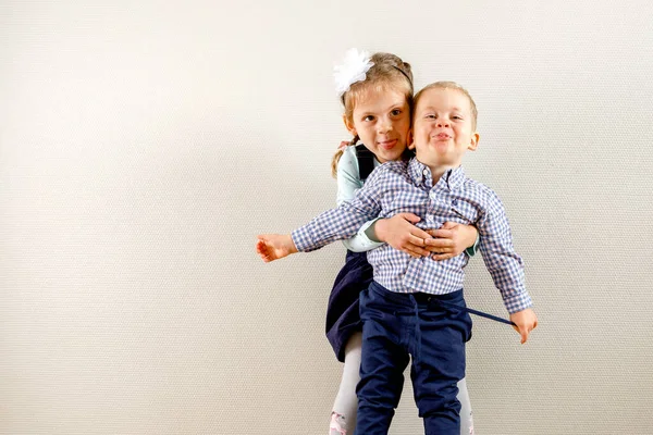 Pequeña Chica Bonita Pie Cerca Hermano Abrazándolo Mientras Ambos Sonríen — Foto de Stock