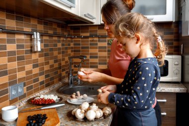 Anne ve kızı mutfakta hazırlansın. Sağlıklı beslenme ve yaşam tarzı kavramı. Aile değeri.
