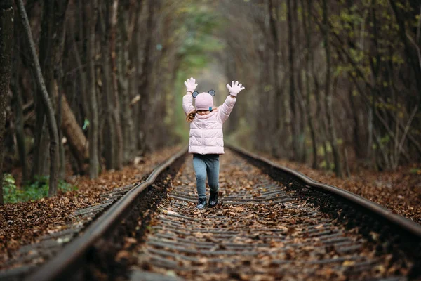 girl in railway green tunnel. love tunnel in autumn. Railway and tunnel from tree