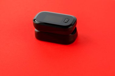 Nabız oksimetresi, beyaz zemin üzerindeki nabız ve oksijen seviyelerini ölçmek için kullanılır.