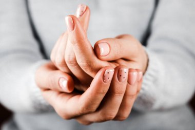 Beyaz arka planda pembe tırnaklı güzel kadın elleri. Tırnak cilası pembe renkte. Manikür, pedikür güzellik salonu konsepti.