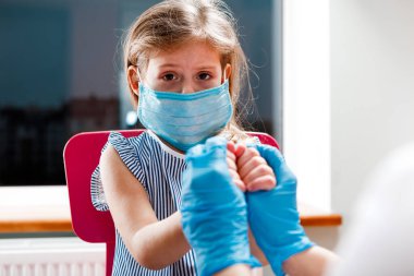 Çocuk aşısı. Hastanede bir çocuğu muayene eden bir doktor. covid-19
