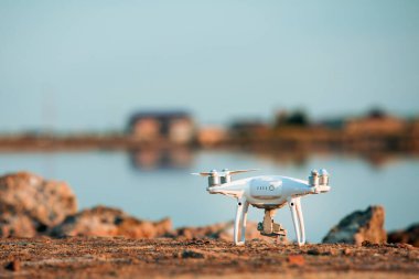 Deniz günbatımının arka planında uçan dron