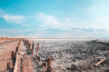 Pembe göl ve kumlu sahil Mavi gökyüzünün altında bulutlu bir deniz koyuyla