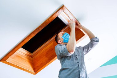 İşçi evdeki çatı penceresini kurar ve kontrol eder