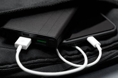 Ahşap masa arkaplanında Power Bank olan cep telefonu.