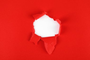 Gazetede yırtık kenarlı kırmızı bir delik var. Noel arkaplanı