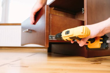 Mavi üniformalı tamirci otomatik tornavidayla çalışıyor. Ev yenileme konsepti.