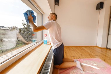 Ofisin camlarını temizleyen genç adam.