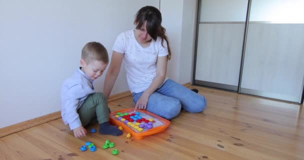 Женщина учит ребенка решать головоломки. — стоковое видео