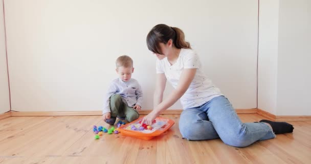 Mujer enseña a niño a resolver puzzles. — Vídeos de Stock