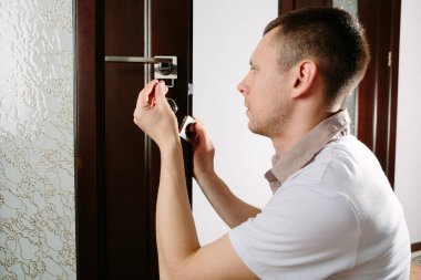 Kapı tokmağını tamir eden bir adam