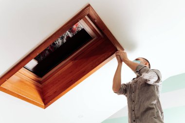 İşçi evdeki çatı penceresini kurar ve kontrol eder