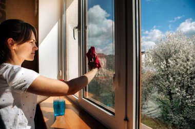 Evdeki pencereyi temizleyen güzel kadın.