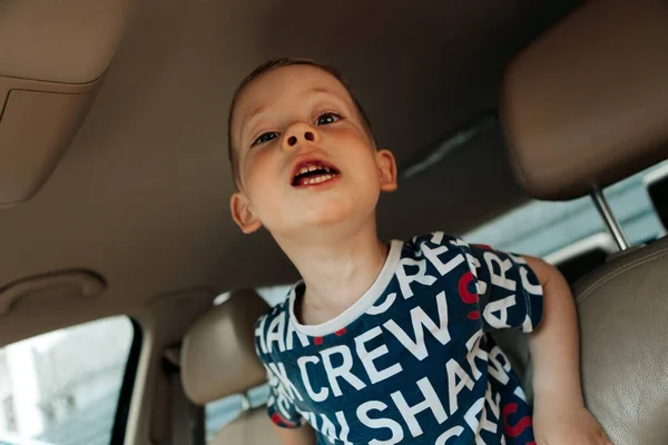 cheerful child in the car in the back seat
