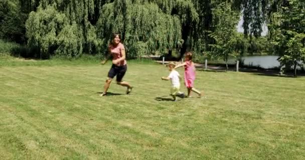 Mama bawi się i bawi ze swoim małym słoneczkiem ciepły letni dzień w parku miejskim — Wideo stockowe