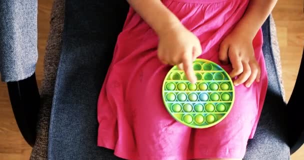 Criança brincando com o Pop It Fidget. Arco-íris Pop it fidget toy — Vídeo de Stock