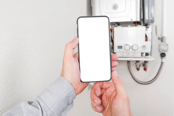 online diagnostics of household appliances via a mobile phone. a man repairing a boiler