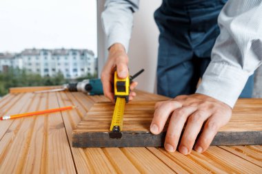 Mavi üniformalı tamirci otomatik tornavidayla çalışıyor. Ev yenileme konsepti.