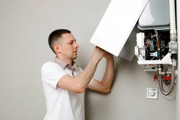 a man repairing a boiler in a medical mask