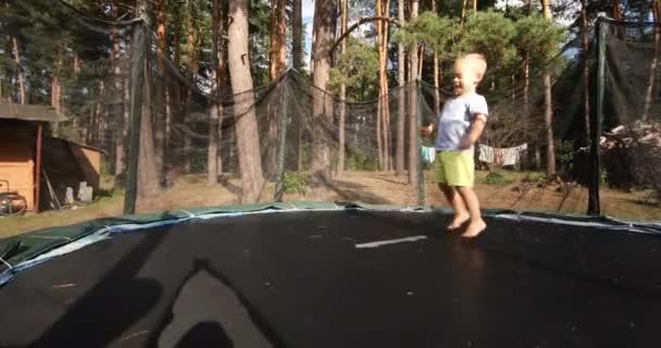 Pojke hoppar på en studsmatta — Stockvideo