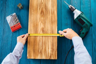 Mavi üniformalı tamirci otomatik tornavidayla çalışıyor. Ev yenileme konsepti.