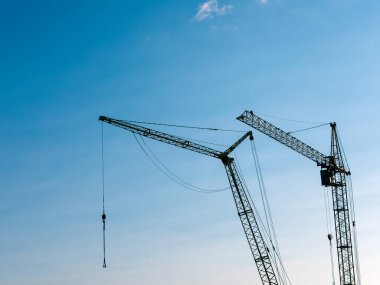 Yeni binaların arka planında vinçler olan inşaat alanı