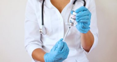 Kadın bir doktor aşıyı şırıngaya yerleştirir ve kovid 19 delta varyantına karşı 