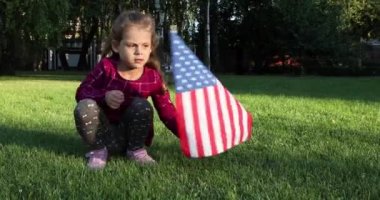 Yazın açık havada Amerikan bayrağı sallayan kız.