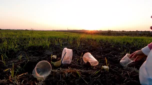 Chica voluntaria recoge basura en la bolsa de basura en la naturaleza — Vídeos de Stock