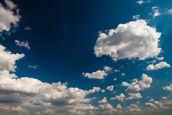 Blauwe hemel met witte en grijze wolken — Stockfoto