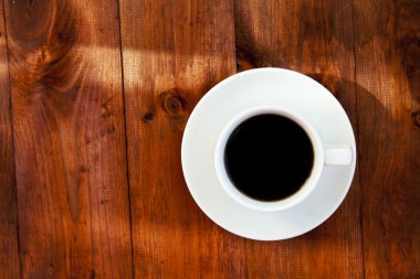 Tahta bir masada bir fincan kahve..