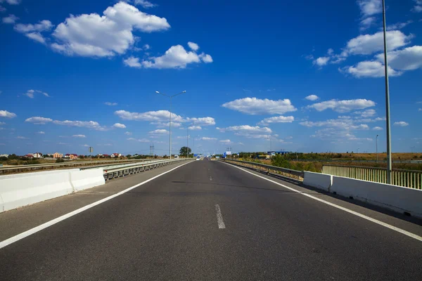 Speed asphalt-paved road anchorwoman from a city — Stock Photo, Image