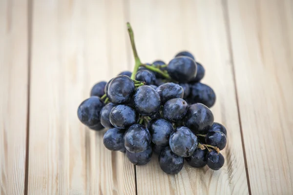 Green and purple round grapes on old wooden table, selective foc — Stock Photo, Image