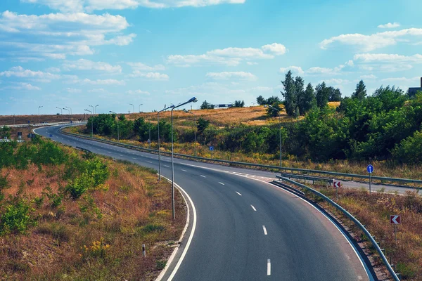 Speed asphalt-paved road anchorwoman from a city — Stock Photo, Image