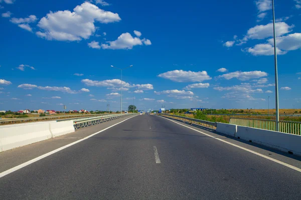 Speed asphalt-paved road anchorwoman from a city — Stock Photo, Image