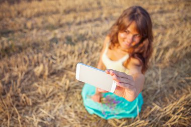 Güzel genç kadın kendini telefon ile fotoğraf çekimi.