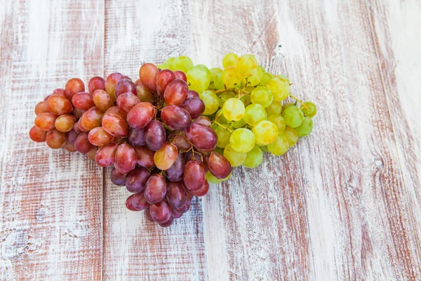 Uvas redondas verdes y moradas sobre mesa de madera vieja, foc selectivo —  Fotos de Stock