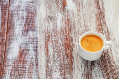 Tahta bir masada bir fincan kahve..