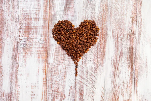 Forma de corazón hecha de granos de café en la superficie de madera. —  Fotos de Stock