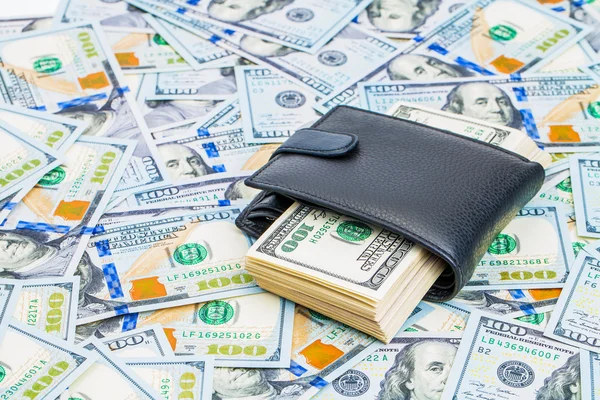 Un bolso es dinero completo aislado en un fondo de dólares — Foto de Stock